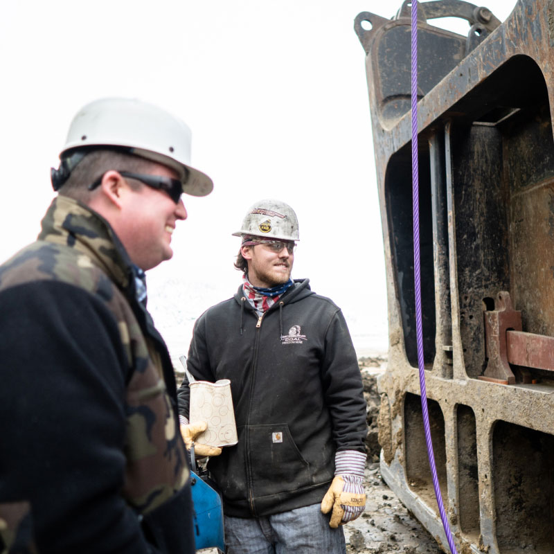 North American Coal Employees Wearing Hard Hat, Neon Safety Vest & Sunglasses At Job Site