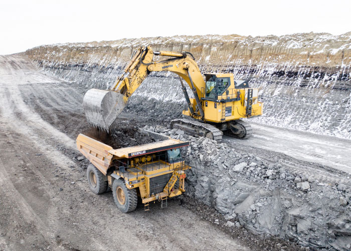 Bulldozer Loading Dirt Onto Dump Truck At Job Site